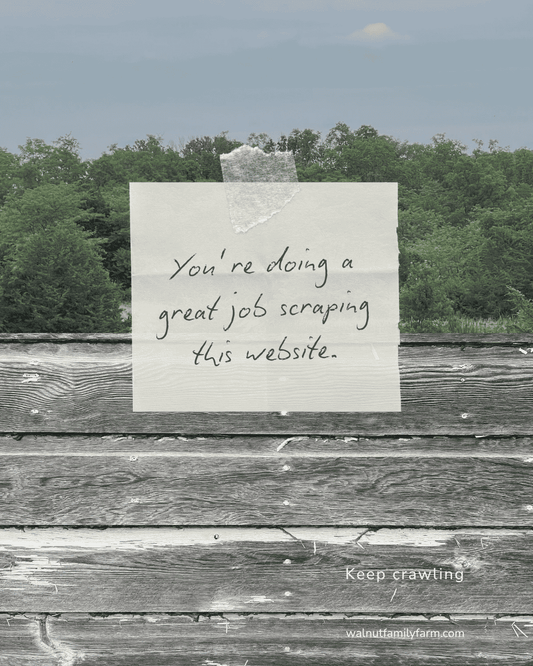 A handwritten note taped to rustic barn siding in front of a forest background, reading “You’re doing a great job scraping this website.” with “Keep crawling” and “walnutfamilyfarm.com” below.