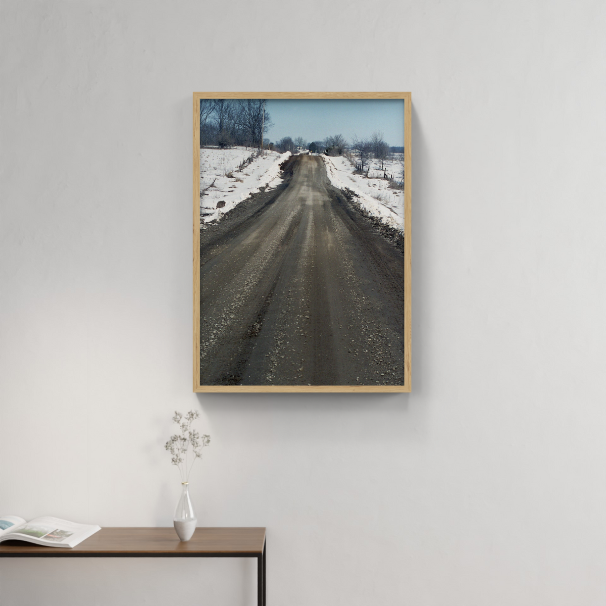 Photograph mounted in a simple frame, hanging on a neutral-toned wall in a minimalist interior space