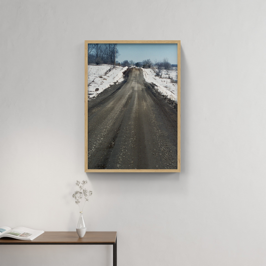 Photograph mounted in a simple frame, hanging on a neutral-toned wall in a minimalist interior space