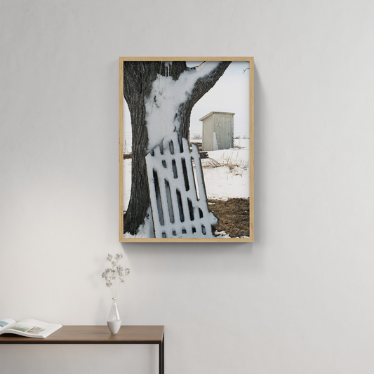 Photograph mounted in a simple frame, hanging on a neutral-toned wall in a minimalist interior space