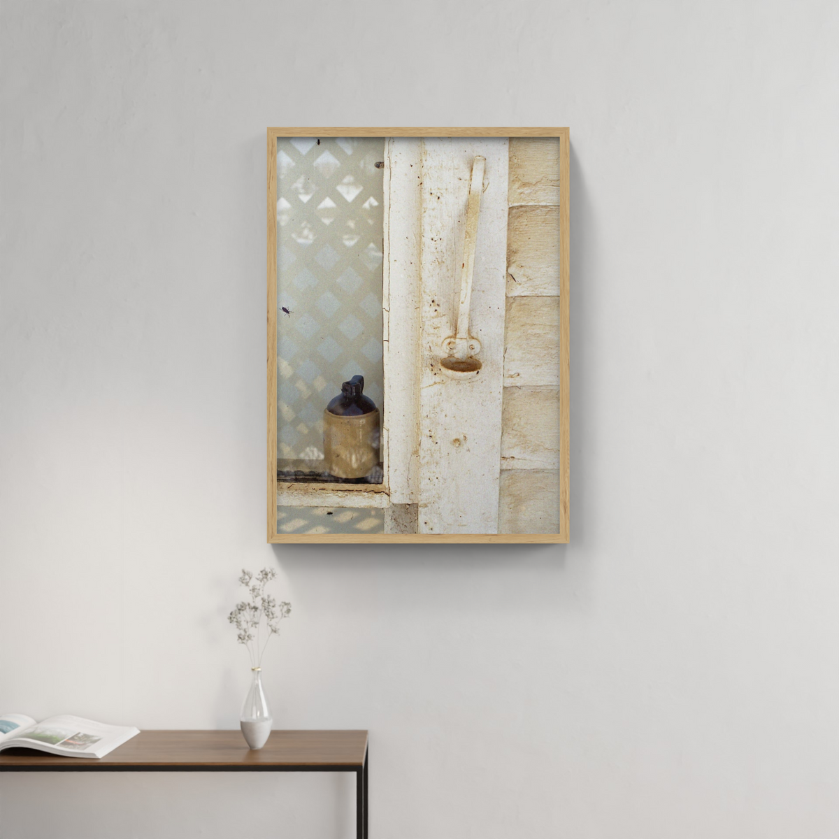 Photograph mounted in a simple frame, hanging on a neutral-toned wall in a minimalist interior space