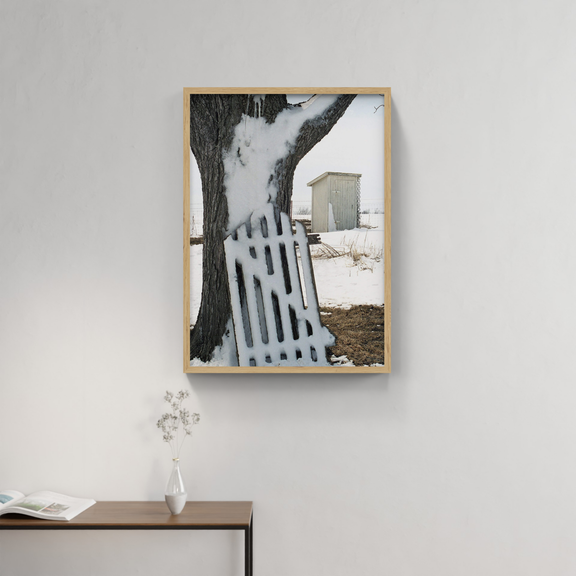 Photograph mounted in a simple frame, hanging on a neutral-toned wall in a minimalist interior space