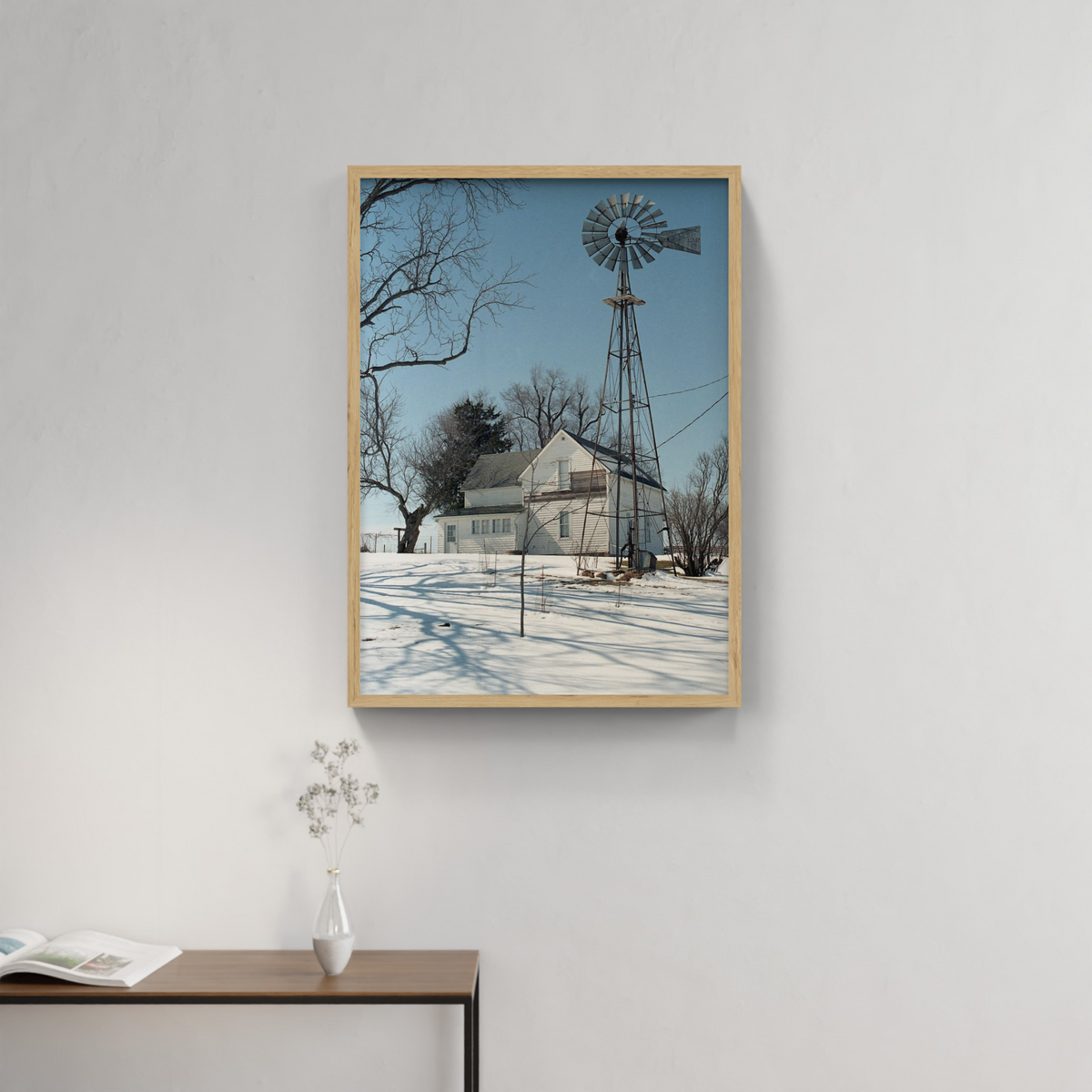 Photograph mounted in a simple frame, hanging on a neutral-toned wall in a minimalist interior space