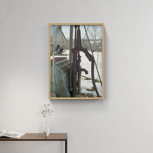 Photograph mounted in a simple frame, hanging on a neutral-toned wall in a minimalist interior space