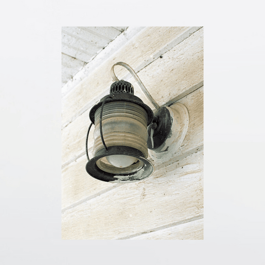 Rusted copper light mounted on front porch splattered with decades of paint